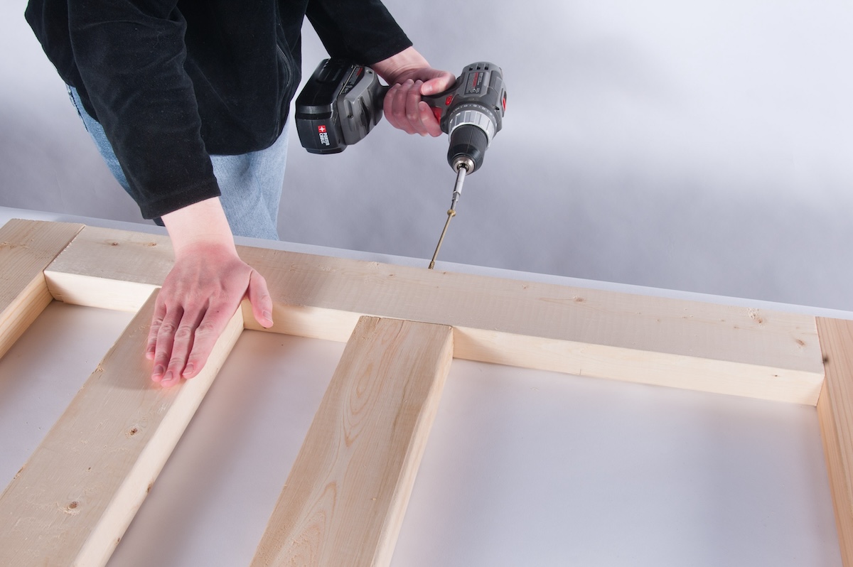 Adding screws to wood planks.